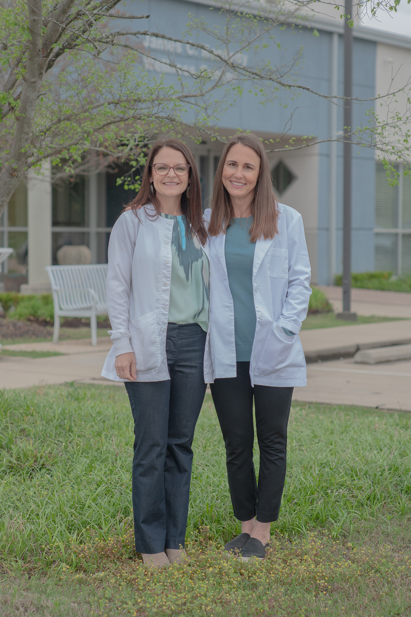 Two women standing side by side for a portrait outside the Wellness Center.