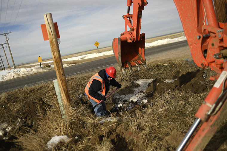 Allen Scott, with Blue Lightning, works on a hole to join fiber optic cable, for high speed internet,